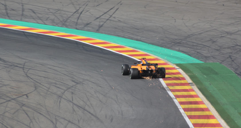 Monoplaza de F1 frenando sobre el pianito de Eau Rouge-Raidillon en el circuito de Spa-Francorchamps