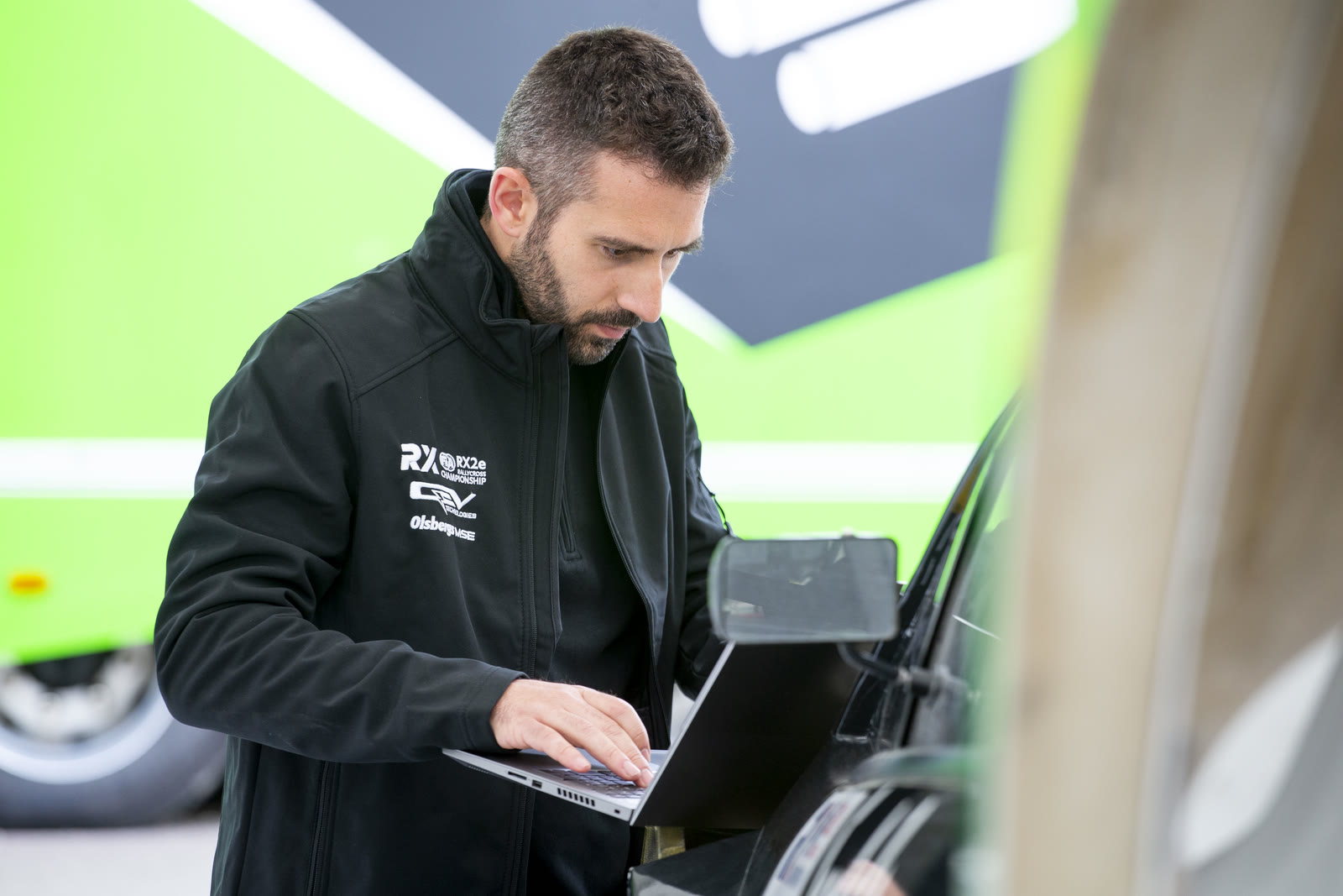 Ingeniero revisando datos de telemetría en un ordenador portátil en el paddock