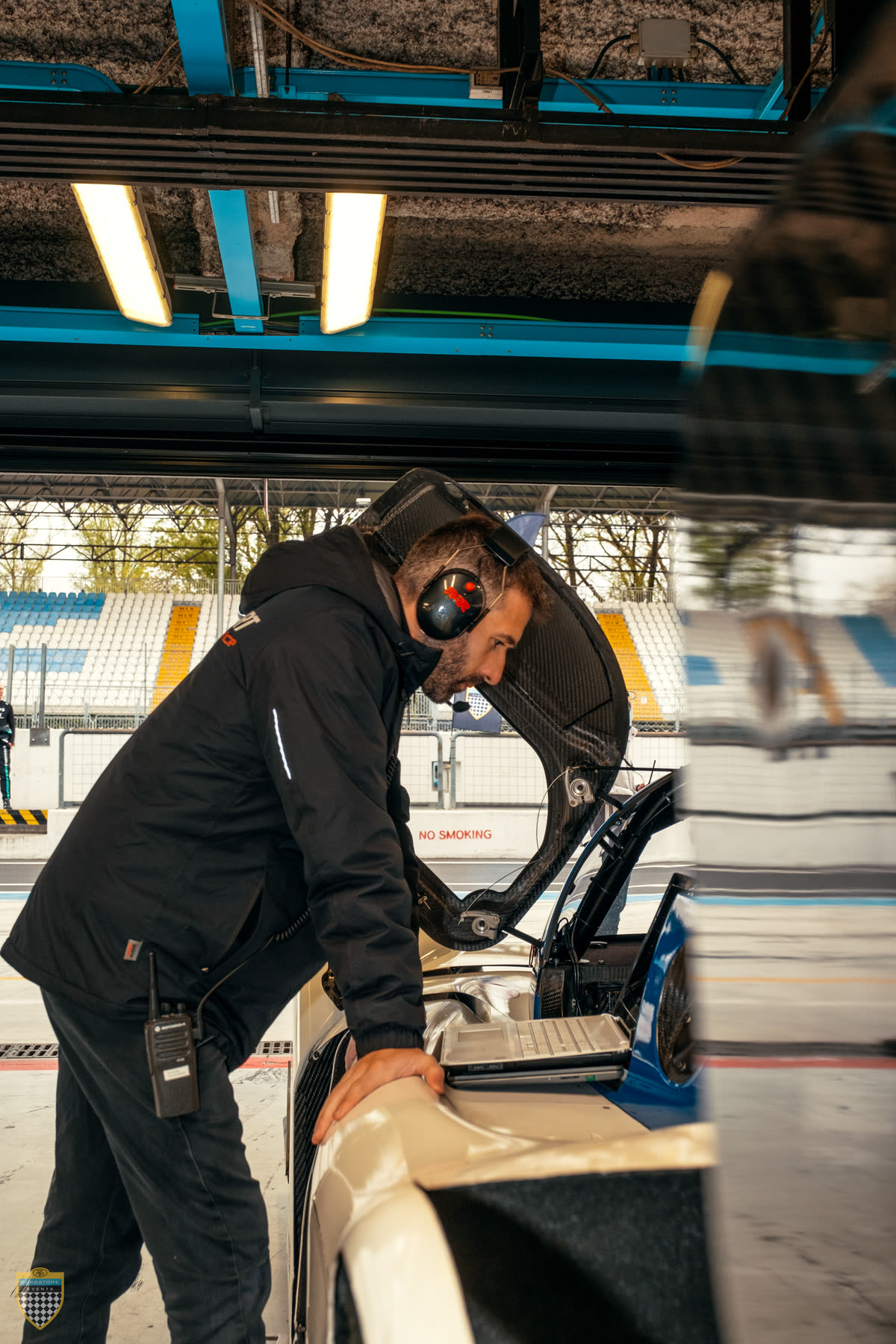 Javier Martín Serna, ingeniero de motorsport, inclinado sobre el cockpit de un prototipo revisando datos en el pit lane