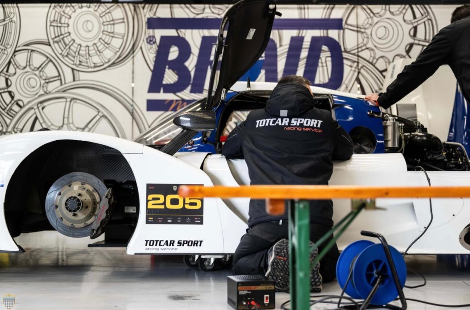 Técnico de Totcar Sport preparando un prototipo LMP3 en el box, con el capó abierto